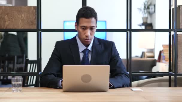 Uomo d'affari nero pensieroso che lavora sul computer portatile — Video Stock
