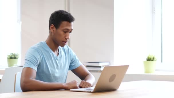 Junger schwarzer Mann arbeitet am Laptop — Stockvideo