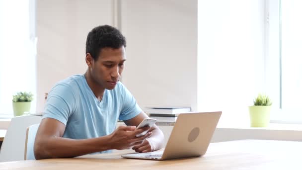 Hablar por teléfono, joven negro en el trabajo — Vídeos de Stock