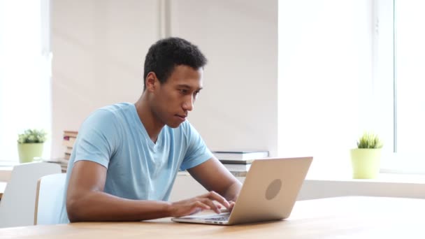 Грустный черный человек расстроен потерей, работа на ноутбуке — стоковое видео