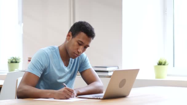 Joven hombre negro escribiendo sobre papel, papeleo — Vídeos de Stock