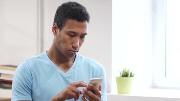 Homem preto jovem navegando em Smartphone — Vídeo de Stock