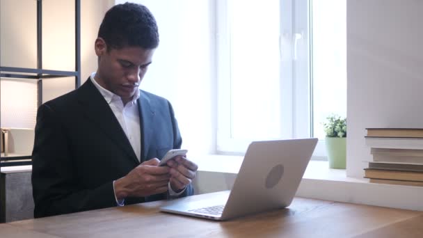 Zwarte zakenman met Smartphone op het werk — Stockvideo