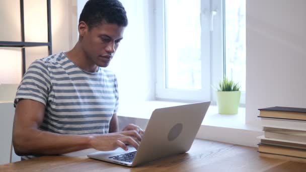 Joven hombre negro trabajando en el ordenador portátil — Vídeo de stock