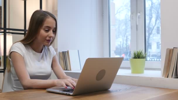 Chica joven celebrando el éxito mientras trabaja en el ordenador portátil — Vídeo de stock