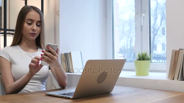 Νεαρό κορίτσι χρησιμοποιώντας Smartphone στο χώρο εργασίας — Αρχείο Βίντεο