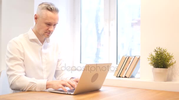 Średnim wieku człowiek pracuje na laptopie, Projektant — Wideo stockowe