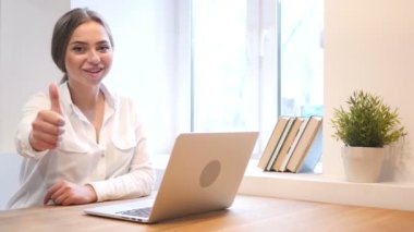 Başparmak yukarıya üstünde Laptop çalışırken genç kız tarafından