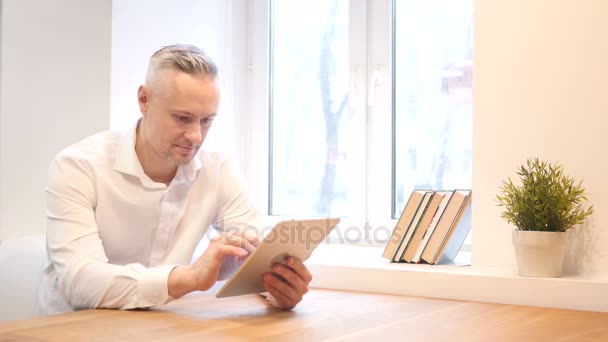 Hombre de mediana edad usando tableta en el trabajo — Vídeos de Stock