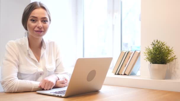 Chica de trabajo en la oficina sonriendo hacia la cámara — Vídeos de Stock