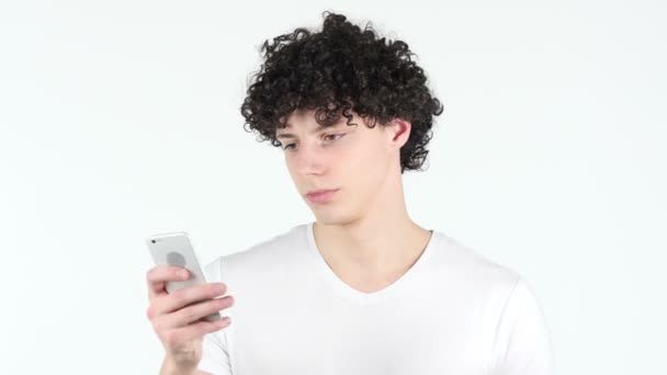 Utilisation de Smartphone, SMS Jeune homme aux cheveux bouclés — Video