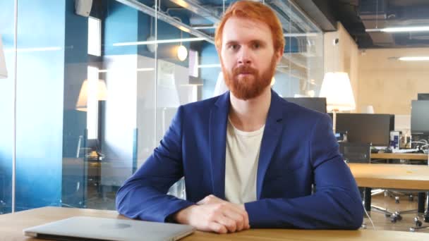 Портрет улыбающегося человека в офисе, рыжие волосы — стоковое видео