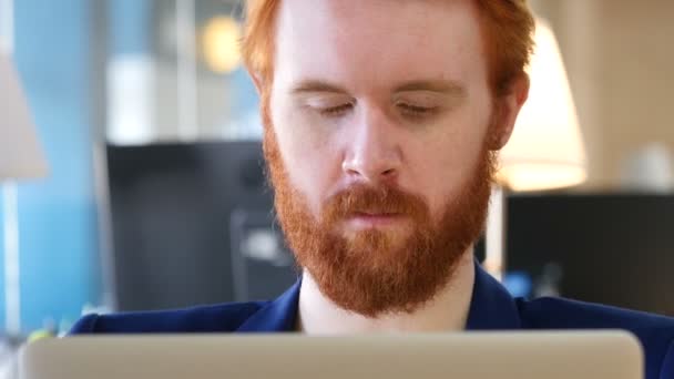 Mann blickt in die Kamera, arbeitet im Büro — Stockvideo