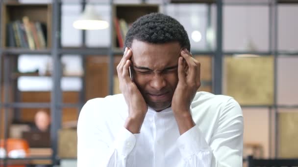 Cansado hombre negro frustrado con dolor de cabeza en la oficina — Vídeo de stock