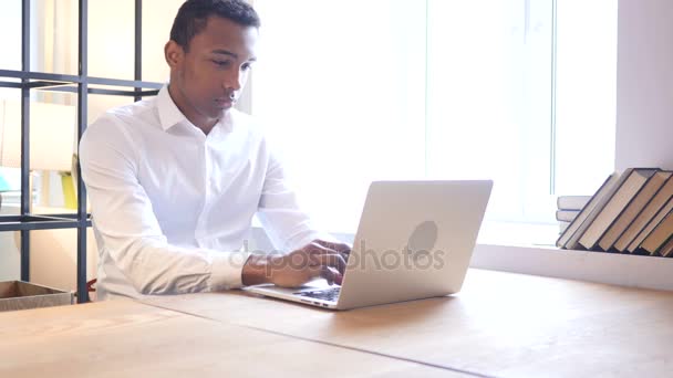 Hombre negro trabajando en el ordenador portátil — Vídeo de stock