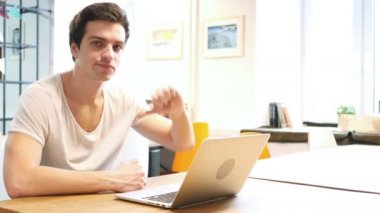Başparmak aşağı üstünde Laptop tasarım çalışarak