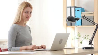 Başparmak yukarıya, kadın ofiste otururken el hareketi