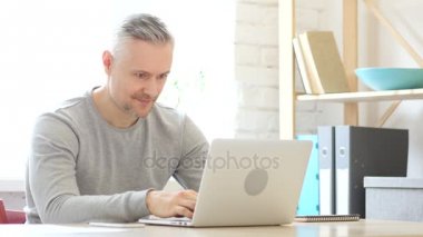 Orta yaşlı adam iş başarısını kutluyor heyecanlı