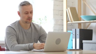 Orta yaşlı adam çalışma üstünde Laptop, yorgun iş yükü