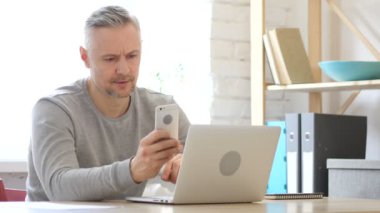 Orta yaşlı adam akıllı telefon, kullanarak kısa mesaj