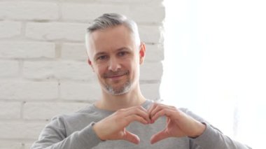 Kalp işareti ile mutlu orta yaşlı adam
