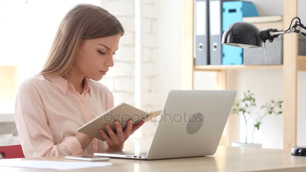 Mädchen bei der Arbeit liest Notizen in Buch — Stockvideo