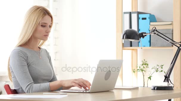 Mujer joven que trabaja en el ordenador portátil en la oficina — Vídeo de stock