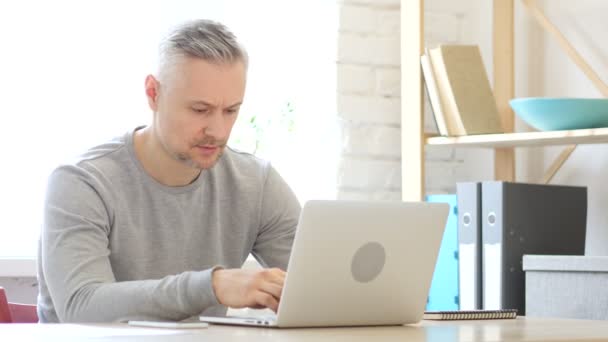 Middeleeuws man werkt op laptop in kantoor — Stockvideo