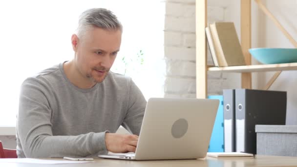 Kciuk w górę połowy wieku człowiek pracuje na laptopie — Wideo stockowe