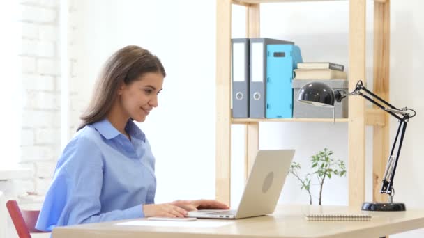 Chat de vídeo en el ordenador portátil por la mujer sentada en la oficina para el trabajo — Vídeos de Stock
