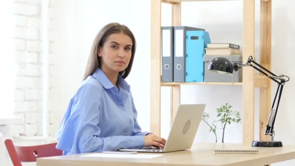 Mujer joven mirando a la cámara en la oficina — Vídeos de Stock