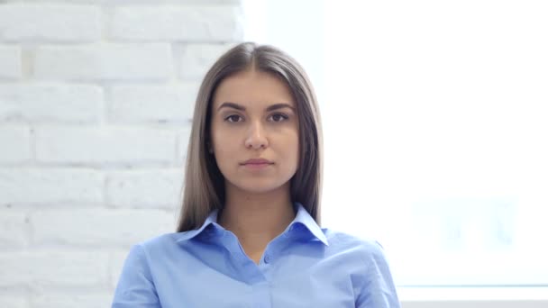 Belle femme assise au bureau, regardant la caméra — Video