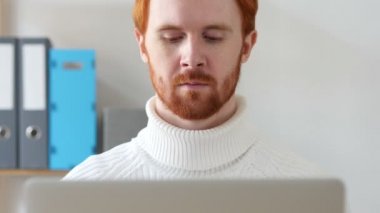 Kırmızı saç ve sakal dizüstü bilgisayarda çalışan adam Close-Up