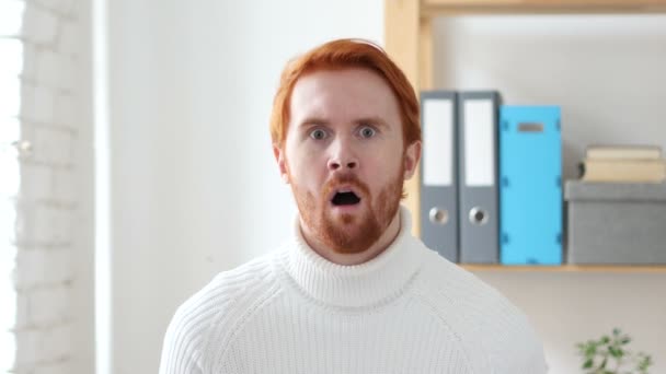 Homme choqué aux cheveux rouges au travail, stupéfié par la surprise — Video