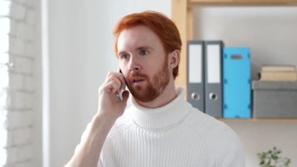Prata på telefon, mannen med röda hårstrån deltar i samtal — Stockvideo