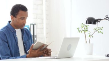 Çalışma ofisinde de Afro-Amerikan adam okuma