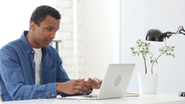 Hombre afroamericano enojado gritando, trabajando en la computadora portátil reaccionando a problemas — Vídeo de stock