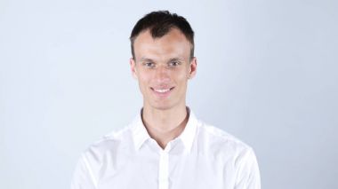 Parkta cep telefonu konuşurken gülümseyen genç adam