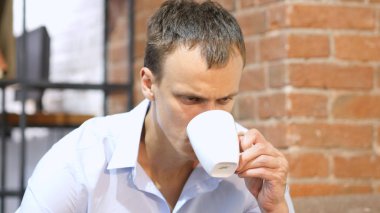 genç çekici adam yaratıcı çalışma alanı içinde bir kahve içme