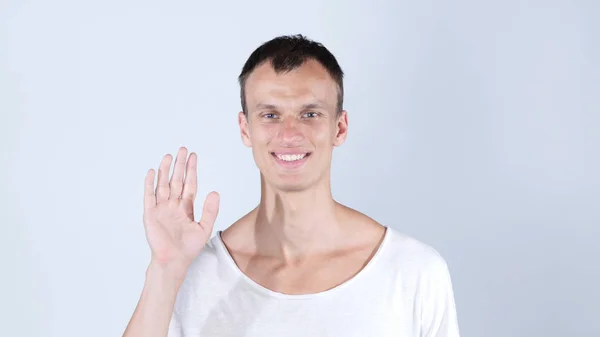 Portrait d'un homme souriant debout et montrant un signe de salut et au revoir — Photo