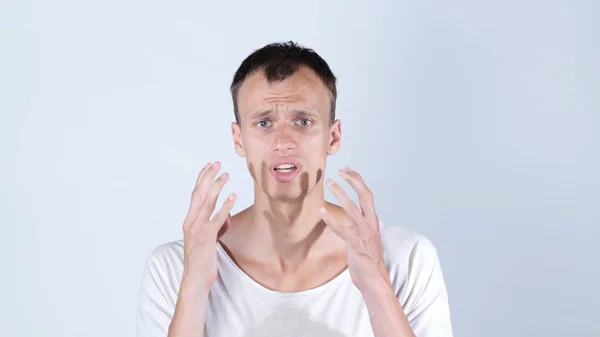 Geschokt man in witte t shirt, witte achtergrond — Stockfoto