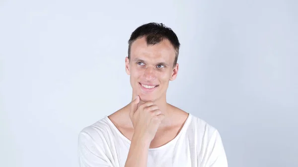 Estou a ter ideia. Sorrindo pensativo bonito homem de pé sobre fundo branco — Fotografia de Stock