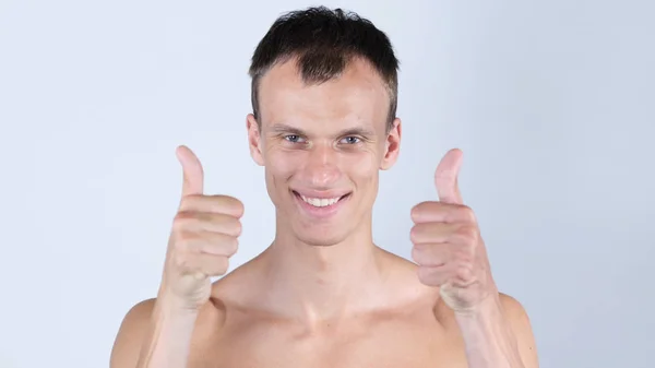 Portrait of young shirtless man shows thumbs up with both hands — Stock Photo, Image