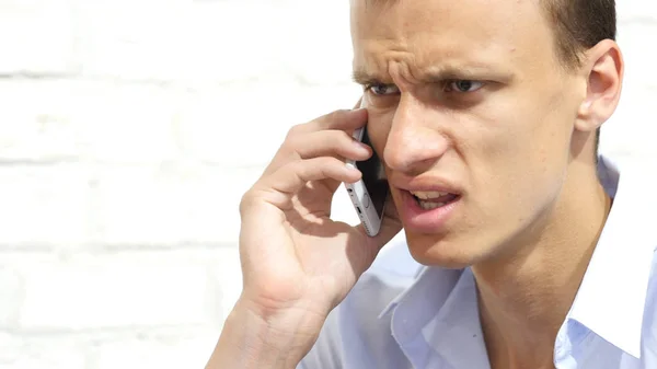 Homem de negócios irritado falando ao telefone, perturbado e sério — Fotografia de Stock