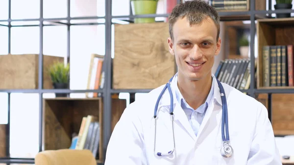 Retrato de Jovem médico sorrindo para a câmera em um escritório no hospital — Fotografia de Stock