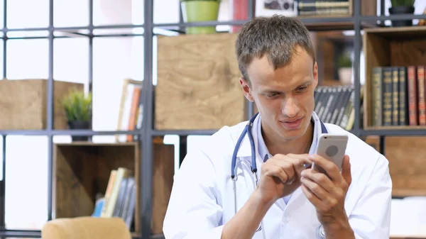 Läkare använder sin smartphone på kontoret — Stockfoto