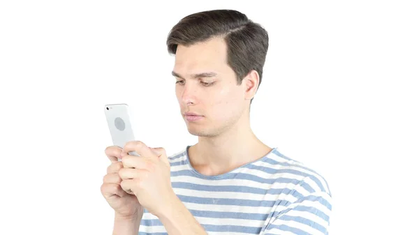 Homem jovem digitando e-mail, sms, massagem no telefone inteligente, fundo branco isolado — Fotografia de Stock