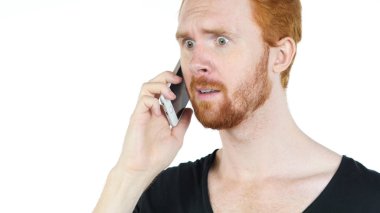 Kırmızı saç adam cep telefonu üzerinde konuşurken vurguladı