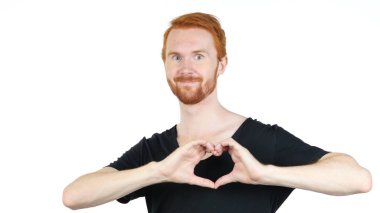 Yakışıklı genç adam elleriyle kalp işareti yapıyor.