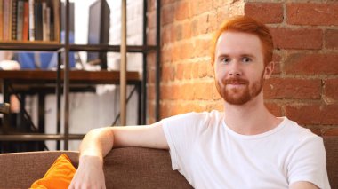 genç adam kamera, Loft onun çalışma evinde oturan bakarak